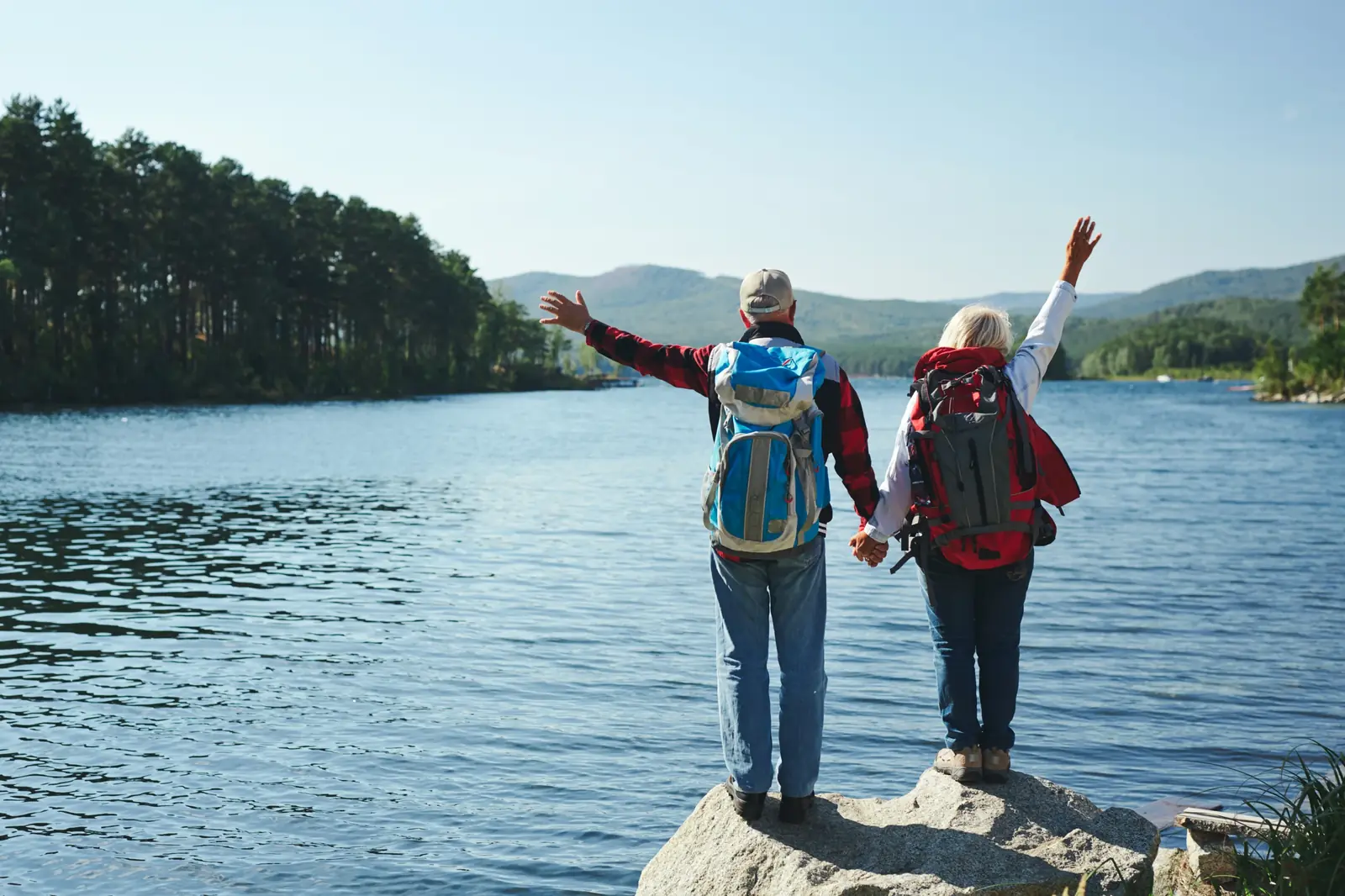 Dvojice s batohy si společně užívá výhled na jezero a hory.